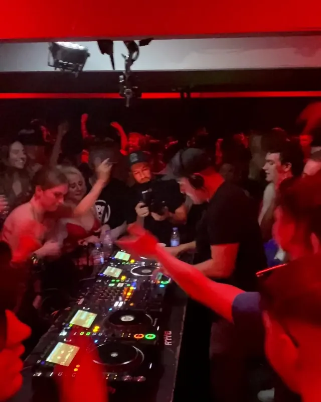 DnB Allstars 360° w/ Break: red-lit crowd leaning in over the 360 booth