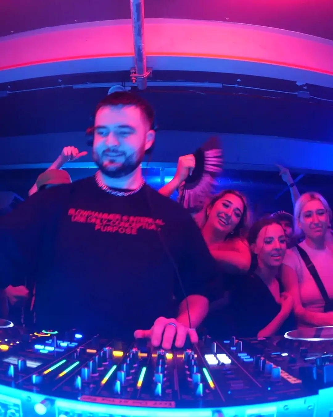 DnB Allstars 360° w/ Kanine: DJ grinning at the 360 decks, crowd dancing behind