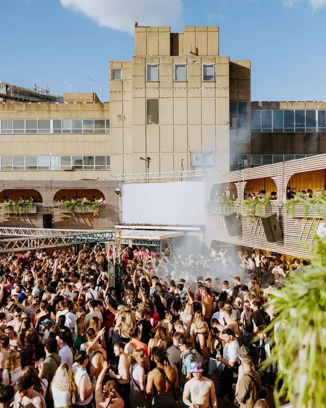 DnB Allstars Censored: Summer Block Party: Huge daylight crowd before the venue tower under blue sky, unmistakably this show