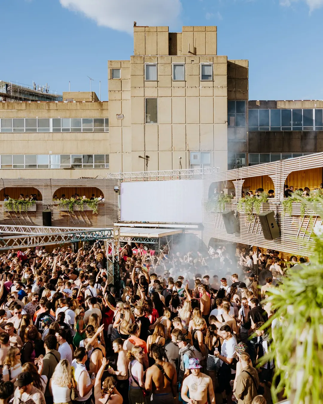 DnB Allstars Censored: Summer Block Party: Huge daylight crowd before the venue tower under blue sky, unmistakably this show