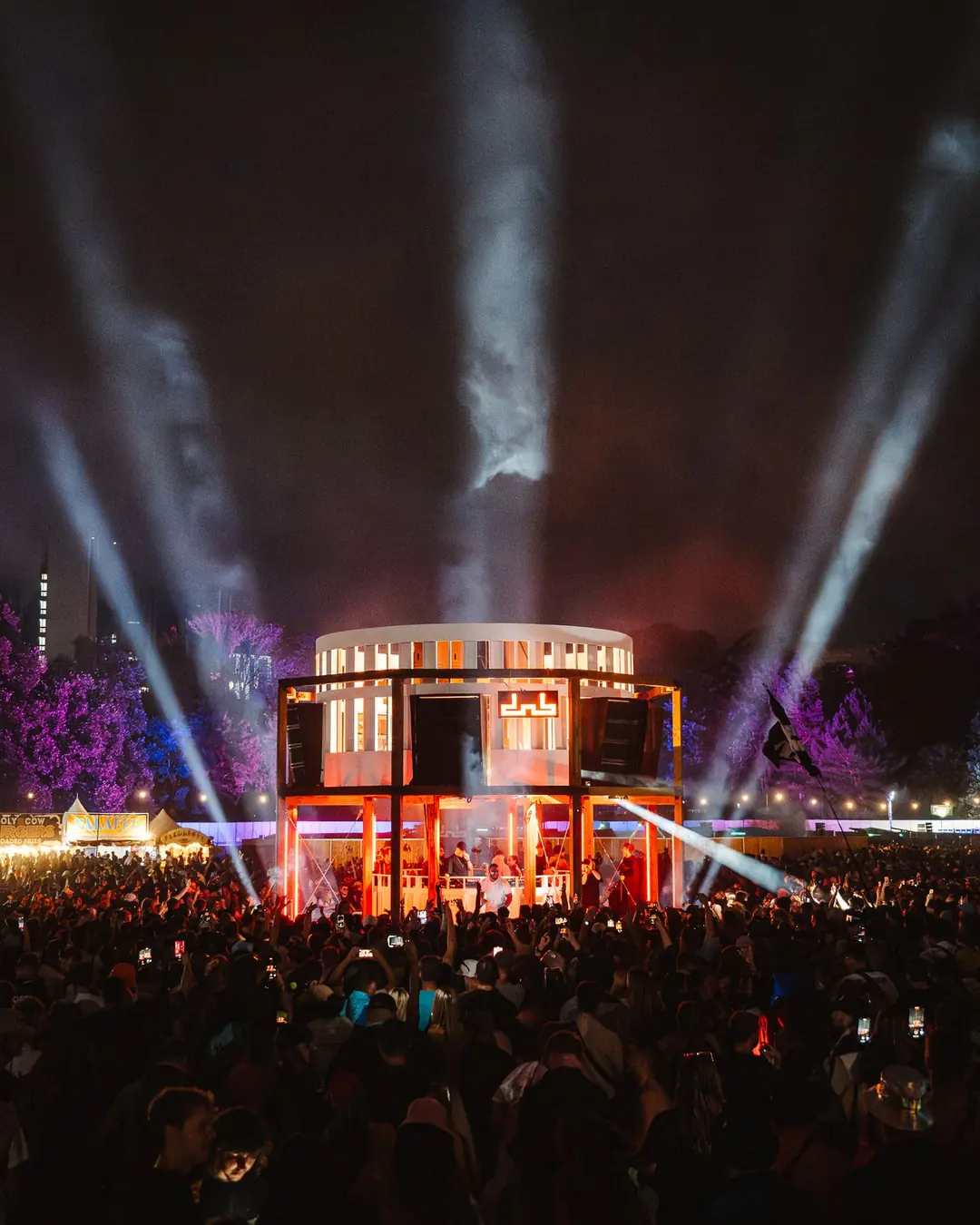 DnB Allstars Festival 2024: Main stage lit at night, searchlight beams fanning into sky over a vast crowd