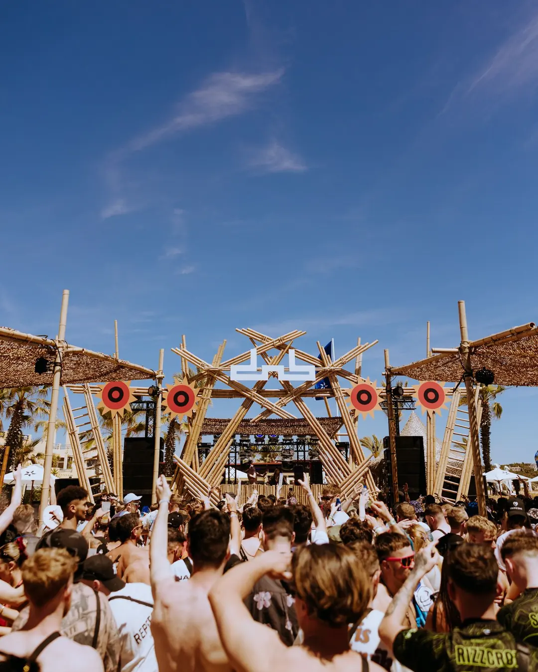 DnB Allstars Portugal 2024: Bamboo dnb main stage, deep blue sky, packed beach crowd