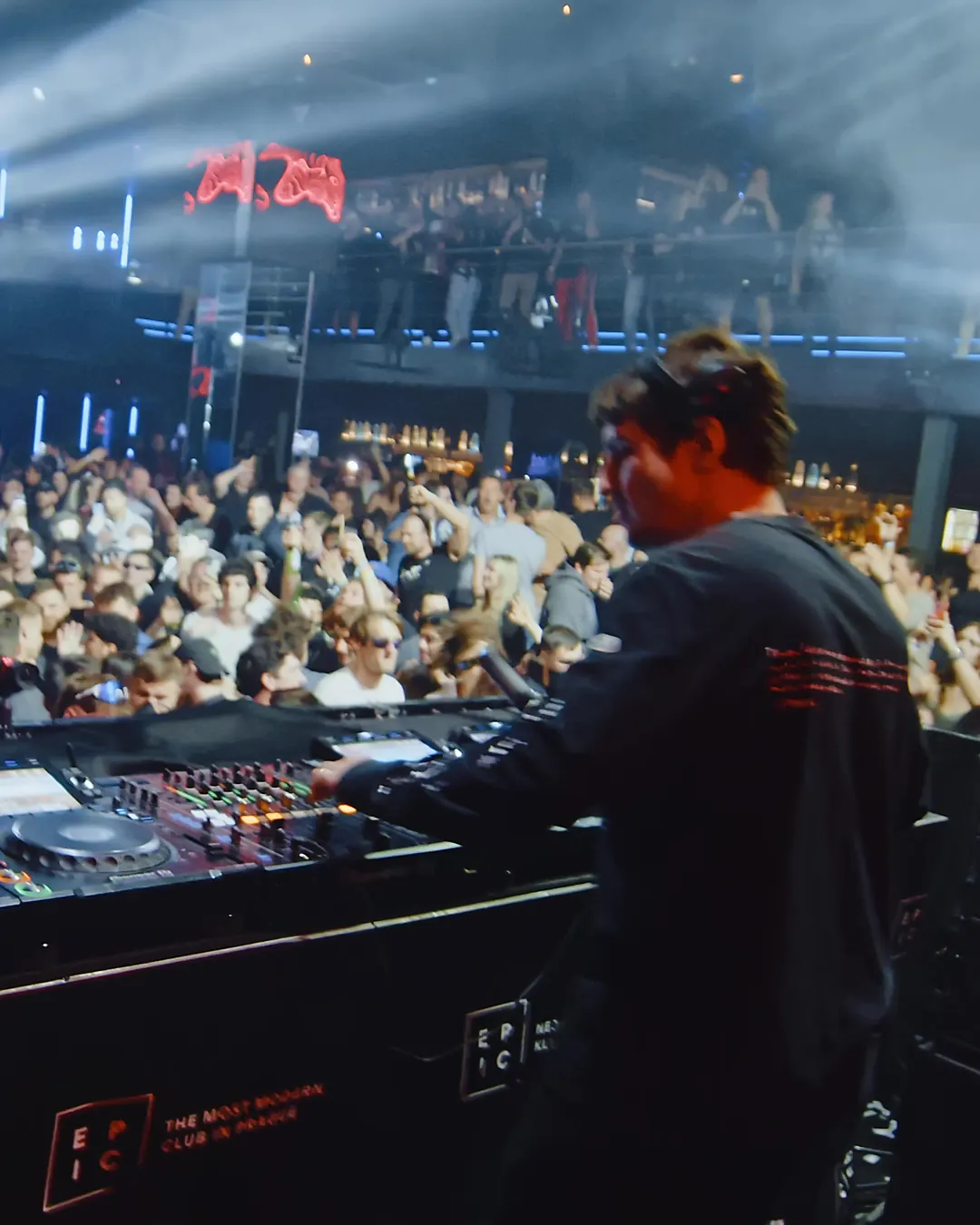 DnB Allstars: Prague: DJ at the decks above a packed Prague room