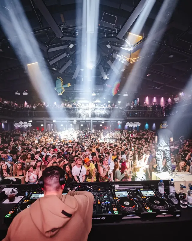 DnB Allstars Summer in the City: London: White beams fanning over a huge crowd, seen from behind the decks