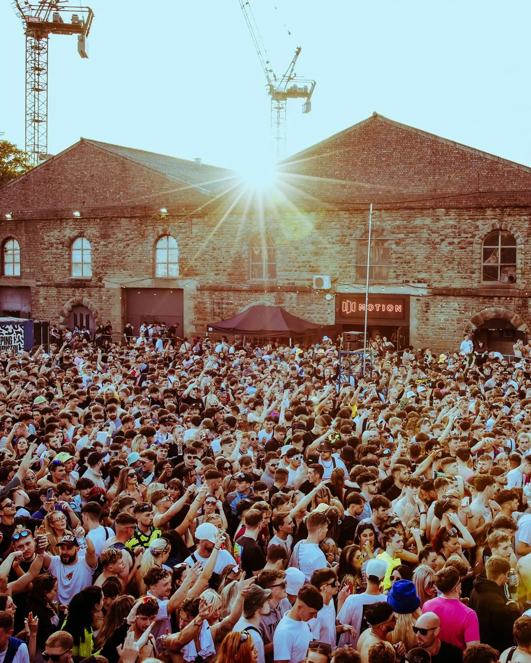 DnB Allstars x 30Hz: Bristol: Sunburst over the stone warehouse and cranes above a vast crowd