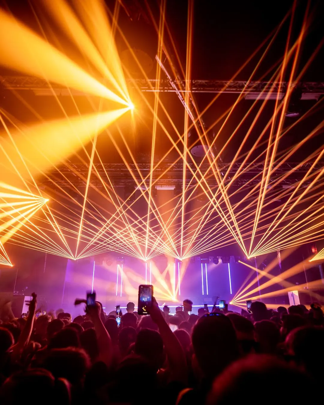 DnB Allstars x 30Hz: Nottingham: Orange laser fans explode over stage and silhouetted crowd, reads instantly at card size